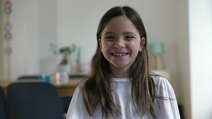 Joyful 8-Year-Old Girl Laughing at Camera, Close-Up Face in Living Room. Happy person, child's real...