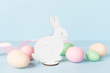 Fototapeta na wymiar Easter eggs and rabbit on color background