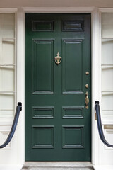 The green front door radiates timeless elegance and invites with a touch of vibrancy in New England.