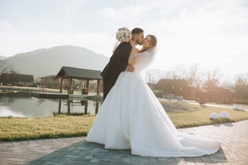 A young bride and groom tenderly embrace in the rays of the autumn sun. Tender and beautiful young...