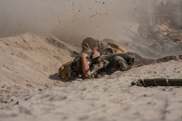 Historic reconstruction. American infantry soldiers from World War II fighting under fire on the beach. 