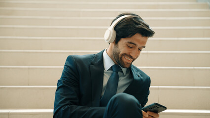 Closeup of smart business man listening and enjoy music while wear headphone. Project manager...