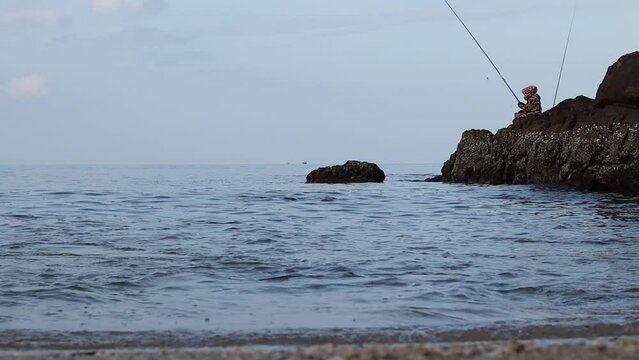 fisherman catches fish on the shore. tropical beach