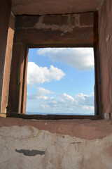 View through an old castle window on a blue sky