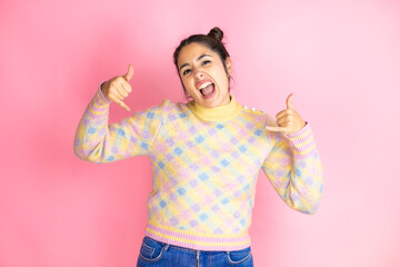 Young beautiful woman wearing casual sweater over isolated pink background shouting with crazy...