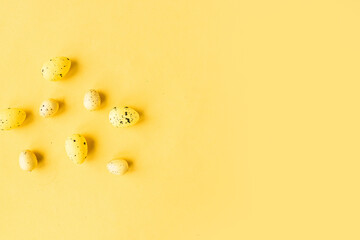 Quail eggs pattern on bright yellow background. Easter festive background. Copy space