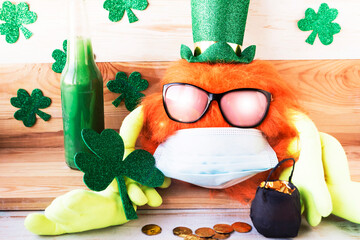 Corona Patricks Day. Toy leprechaun with ginger beard in face medical mask and sunglasses. Saint...