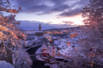 Winter view of Cesky Krumlov, picturesque houses under the castle with snow-covered roofs. Narrow...