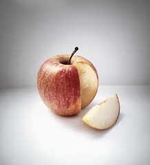 Fresh ripe apple with a cut piece on a white background
