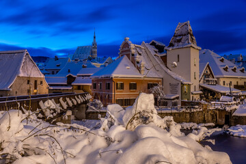Winter view of Cesky Krumlov, picturesque houses under the castle with snow-covered roofs. Narrow...