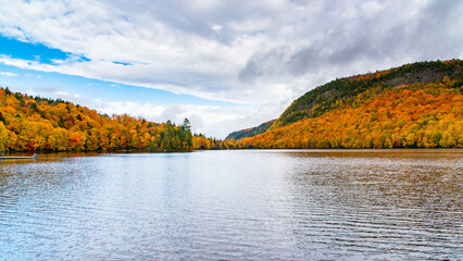 Lac-du-missionaire, Canada: Oct.10 2022: Morning fog on the lake of Lac-du-missionaire with colorful leaves in Quebec in a sunny autumn day