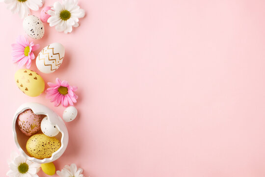 Pastel Easter: eggs and flowers awaiting spring wishes. Top view photo of decorated eggs, ceramic bunny, chrysanthemums on pastel pink background with space for heartfelt Easter greetings