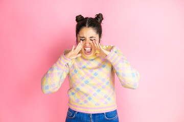 Young beautiful woman wearing casual sweater over isolated yellow background shouting and screaming...