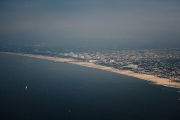 Aerial view looking at the busy, built-up coastline of Los Angeles. An endless urban sprawl meets a...