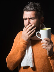Man coughs. Sick male with cold or bronchitis coughing. Bearded handsome male in orange sweater...