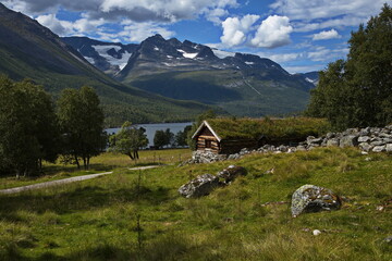 Old wooden cottage with green roof in Innerdalen valley, Norway, Europe
