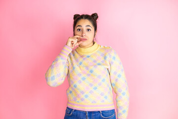 Young beautiful woman wearing casual sweater over isolated pink background mouth and lips shut as...