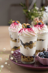 Whipped cream dessert with blueberries and cookies among flowers