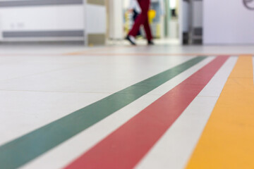 Colorful guide lines on the floor of the hospital corridor for navigation with a blurred hospital...