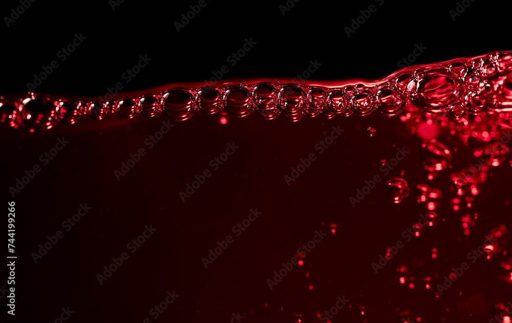 Wall mural red wine on a black background, abstract splashing.