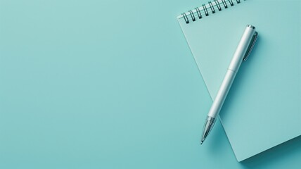 Notebook and pen on a light blue background, top view
