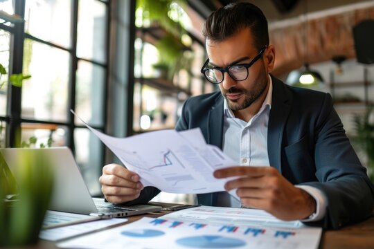 A man is quietly sitting at a table, engrossed in reading a piece of paper, Focused businessman examining a detailed business report, AI Generated
