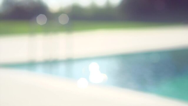 Swimming pool abstract defocused background. Blurred backdrop with blinking water, bokeh. Vacation concept. Slow motion. 