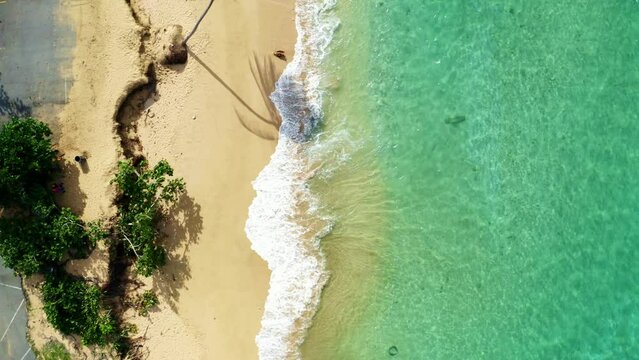 Drone over Penon Amador Beach on a sunny day with the coast erosion destroying road next to it