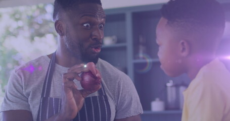 Image of lights over happy african american father and son cooking together