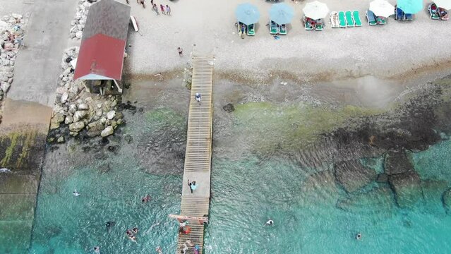 Playa piskado in curacao with colorful beach umbrellas and boats, aerial view