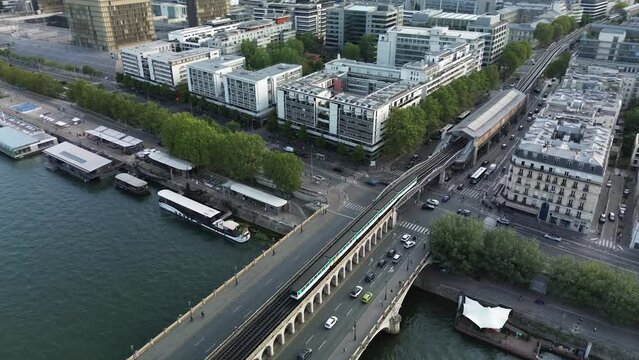 Metro train passing on Bercy bridge towards Quai de La Gare station, Paris in France. Aerial top-down orbiting