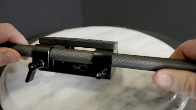 Unscrewing the thumbscrews on the base.