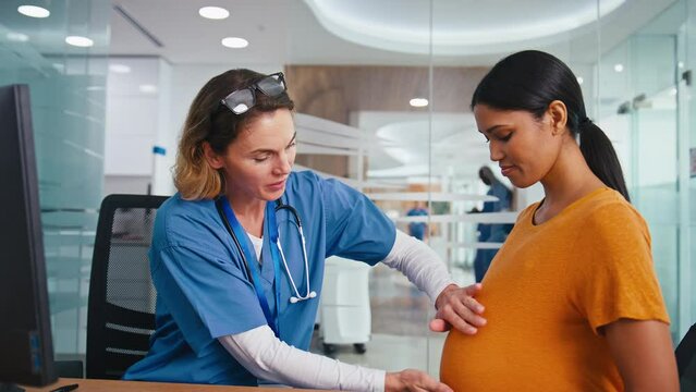 Female Nurse Or Doctor Wearing Scrubs Examining Pregnant Woman In Hospital Obstetrics Clinic
