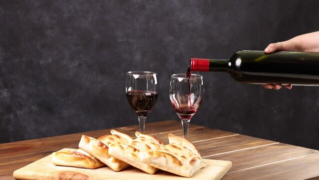 Chilean wine glasses and bottle and empanadas variety. Chile Food background. Fresh ingredients on wood. Selective Focus.
