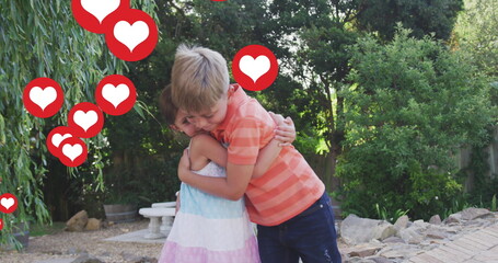 Image of heart icons over caucasian sibling hugging in garden