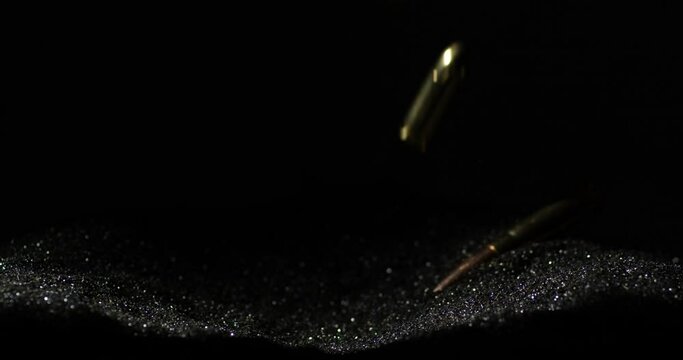 300 BLK And 9mm Parabellum Bullets Falling Into Bullet Grains. slow motion, studio shot