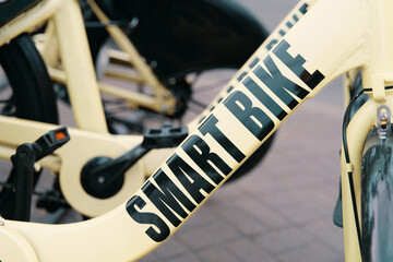 A detailed shot of a sleek bicycle parked on a sidewalk, showcasing its advanced features like a...