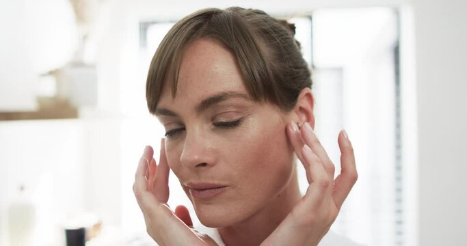 Middle-aged Caucasian woman touches her temples gently