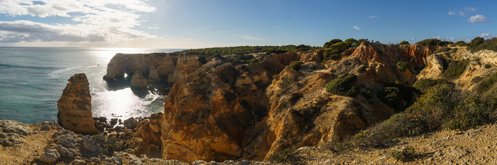 Panorama of golden rock cliffs at the coastline of the Atlantic Ocean with near the Cave of...