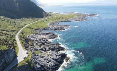 Scenic view of a winding mountain road dotted with coastal rocks. Henningsvaer, Norway.