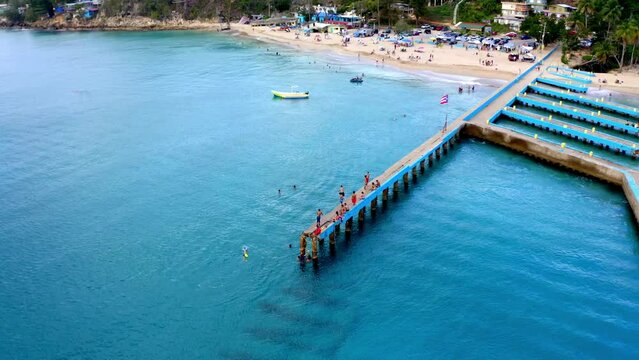 Drone footage of people on the dock jumping in water near the beach in Puerto Rico
