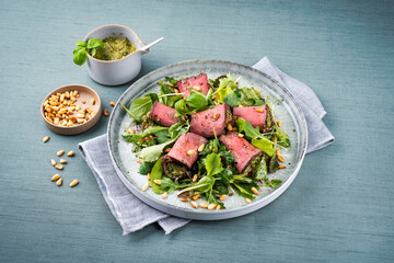 Traditional mixed salad with spinach filled roast beef rolls and pine nuts served as a close-up on...