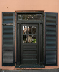 Facade of a building with a window and door beside a sidewalk