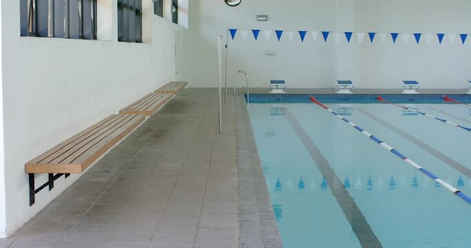 An indoor swimming pool awaits swimmers, with copy space