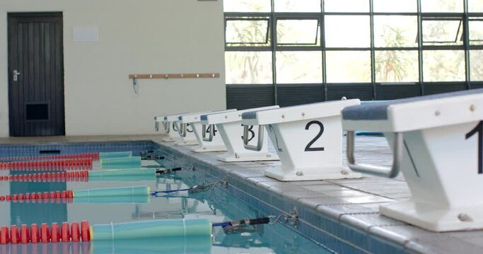 Starting blocks line up at an indoor swimming pool, ready for a race