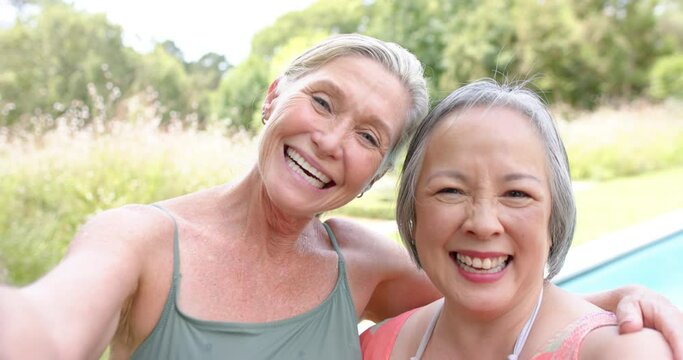 Senior diverse friends smile for a selfie outdoors