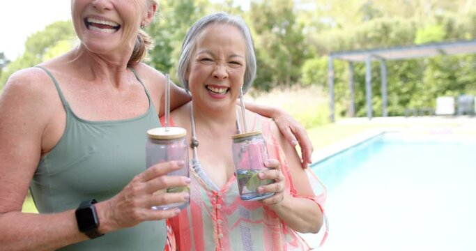 Senior Caucasian woman and Asian woman are smiling outdoors