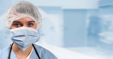 Portrait of female surgeon wearing face mask against hospital in background