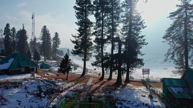 trees , houses, and snow pull back drone shot 4k.gulmarg, jammu and kashmir, india