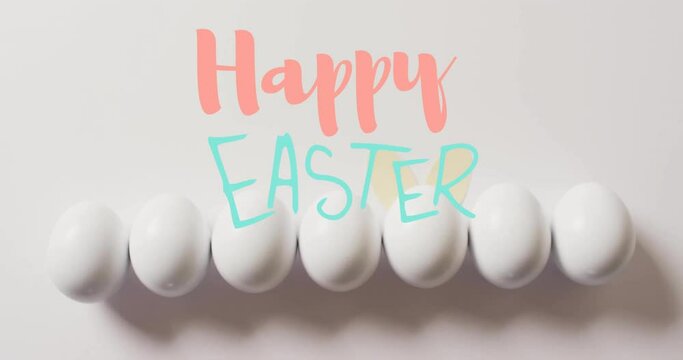 Animation of happy easter text over white easter eggs on white background